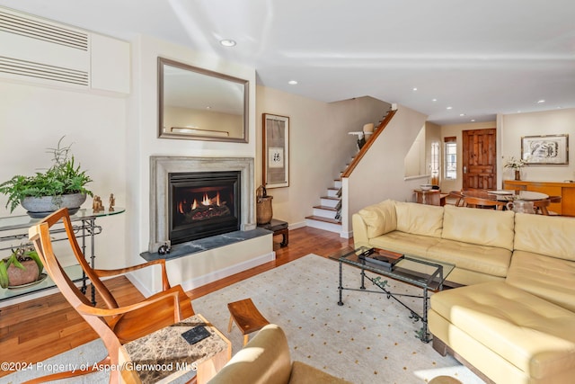 living room featuring a wall mounted air conditioner and light hardwood / wood-style floors