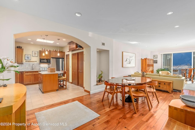 dining space with sink and light hardwood / wood-style floors