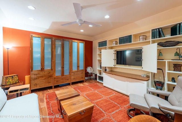 living room featuring hardwood / wood-style floors and ceiling fan