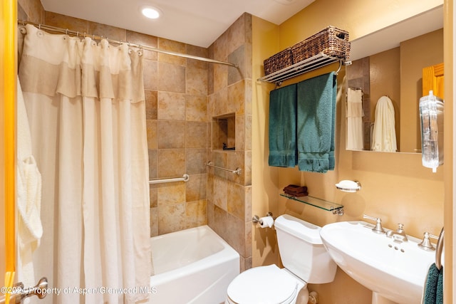 full bathroom featuring sink, shower / bath combo, and toilet