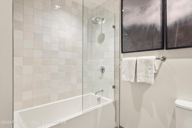 bathroom with tiled shower / bath combo and toilet