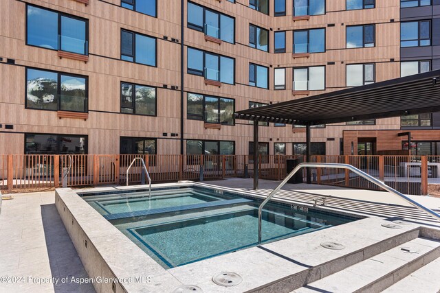 view of swimming pool featuring a jacuzzi