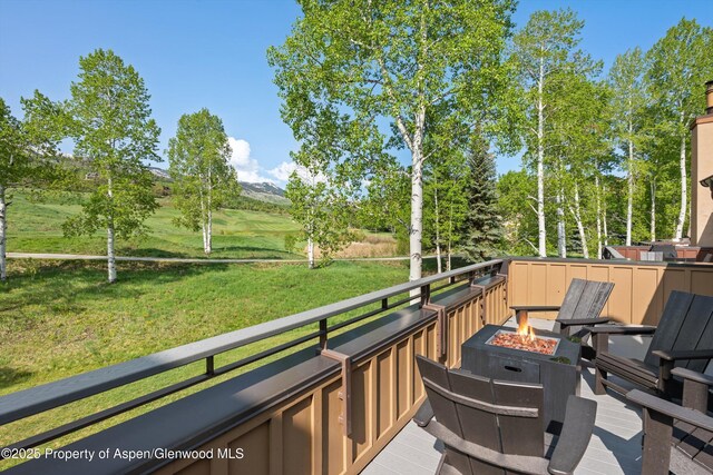 294 Snowmass Club Cir Unit 1207, Snowmass Village, CO 81615 - wooden terrace featuring an outdoor fire pit, a mountain view, and a yard