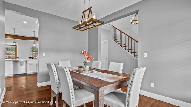 dining space featuring baseboards, dark wood-type flooring, an inviting chandelier, and stairs