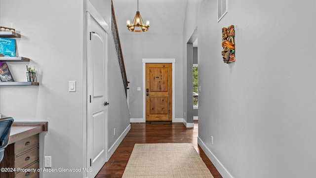 entryway featuring an inviting chandelier, baseboards, visible vents, and dark wood-style flooring