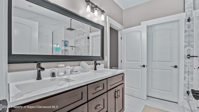 bathroom featuring double vanity, marble finish floor, a walk in shower, and a sink