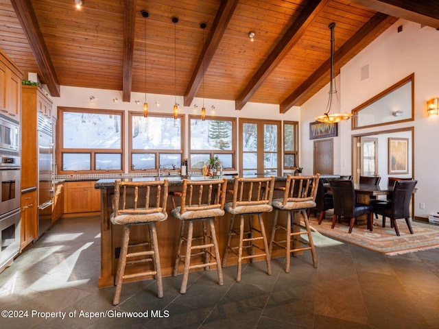 interior space with pendant lighting, high vaulted ceiling, wooden ceiling, and beam ceiling