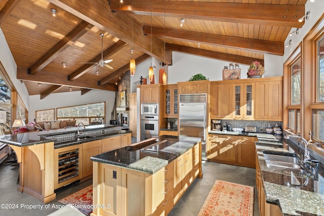 kitchen with high vaulted ceiling, a large island with sink, built in appliances, beamed ceiling, and wood ceiling