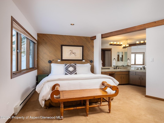 bedroom featuring baseboard heating, wooden walls, sink, and light colored carpet