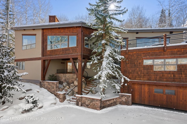 view of snow covered back of property