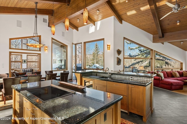 kitchen with pendant lighting, wooden ceiling, high vaulted ceiling, an island with sink, and beamed ceiling