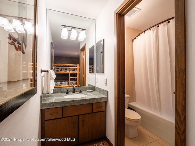 full bathroom featuring tile patterned floors, vanity, shower / bath combination with curtain, and toilet