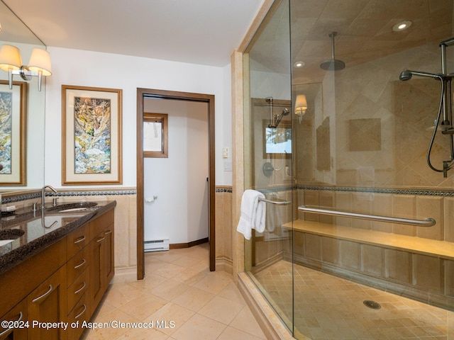 bathroom featuring vanity, a baseboard radiator, tile walls, tile patterned flooring, and a shower with shower door