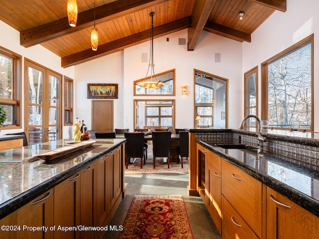 kitchen featuring sink, beamed ceiling, pendant lighting, and french doors