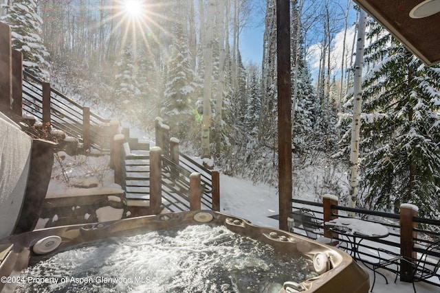 snow covered deck featuring a hot tub