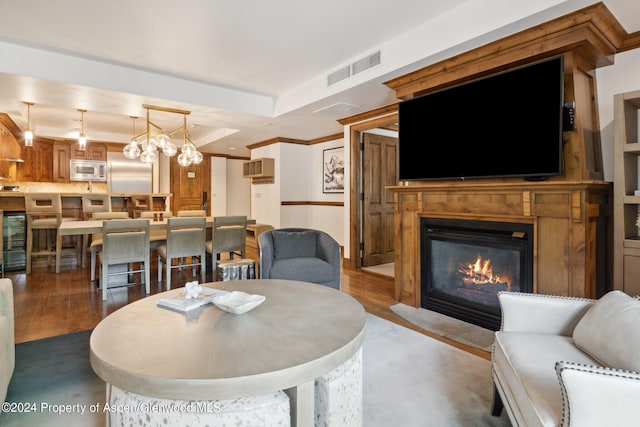 living room with hardwood / wood-style flooring, beverage cooler, and a chandelier