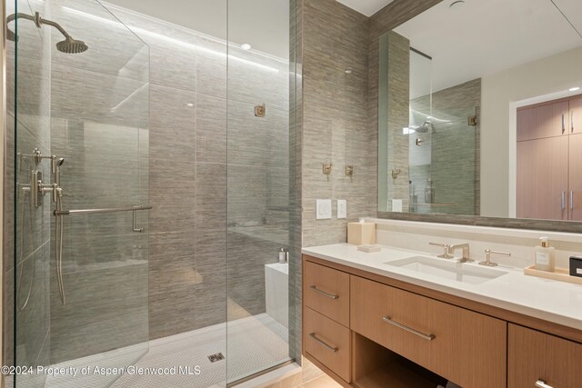 bathroom with vanity and a shower with door