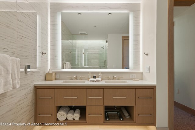 bathroom with a shower with door and vanity