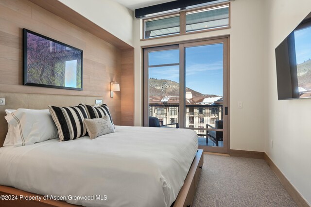 bedroom featuring access to exterior, carpet floors, and wooden walls