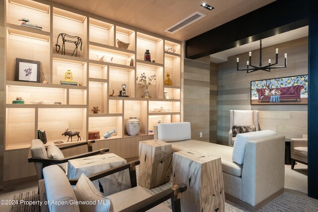 living area with a notable chandelier and wooden ceiling