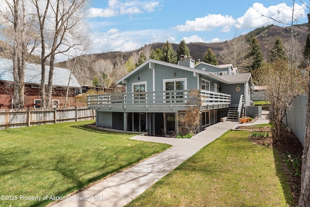 534 Spruce St, Aspen, CO 81611 - rear view of house with a chimney, a lawn, fence, a deck with mountain view, and stairs