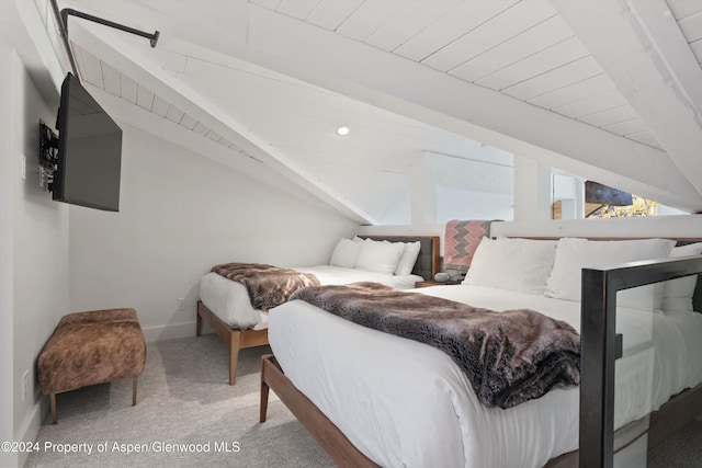 bedroom featuring carpet flooring and vaulted ceiling with beams