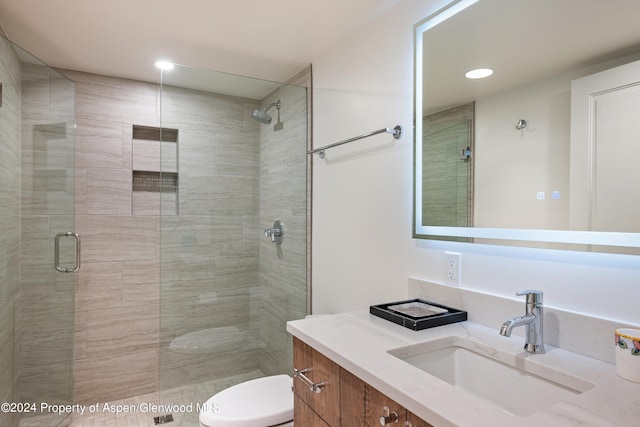 bathroom with vanity, toilet, and an enclosed shower