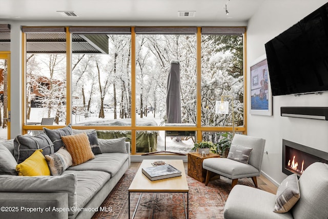 living room with wood-type flooring and floor to ceiling windows