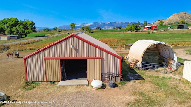 view of outdoor structure with a mountain view and a rural view