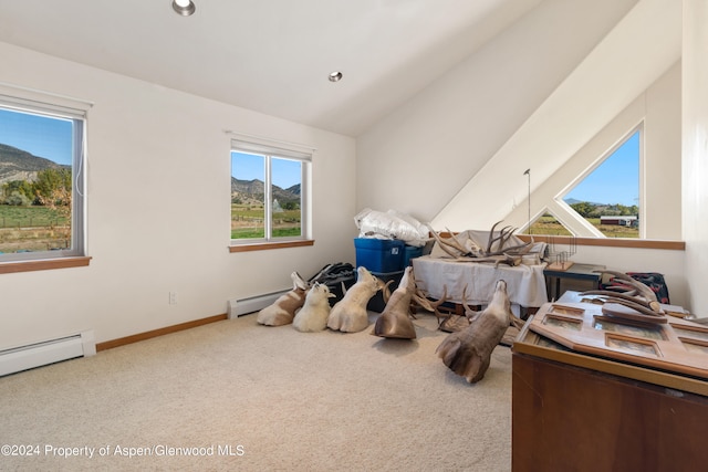 interior space featuring a mountain view, lofted ceiling, carpet floors, and a baseboard heating unit