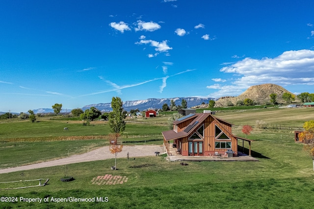 view of playground with a mountain view, a yard, and a rural view