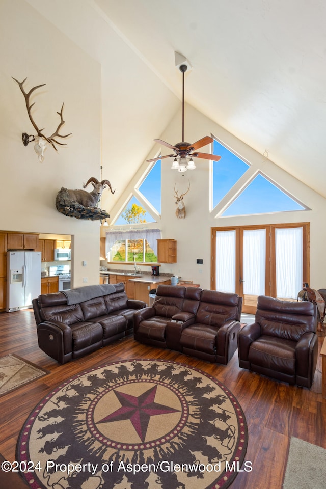 living room featuring dark hardwood / wood-style floors, ceiling fan, sink, and high vaulted ceiling