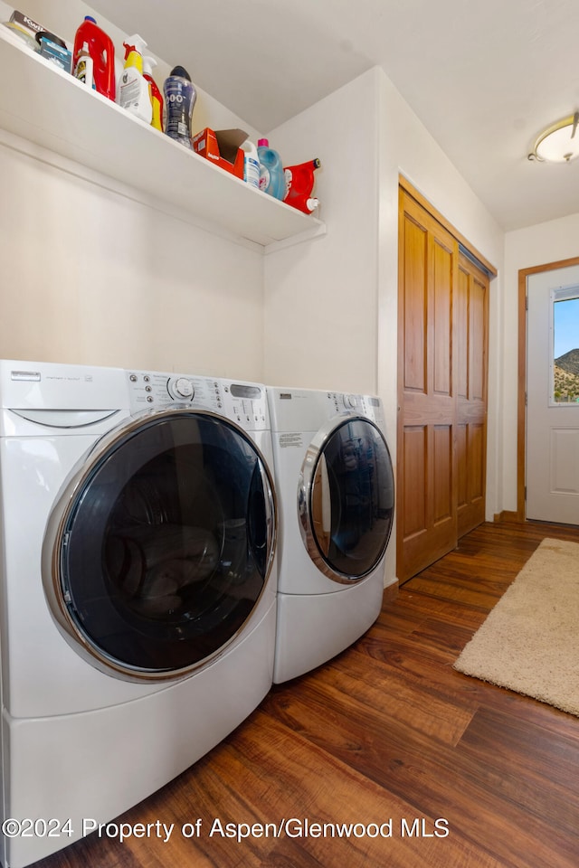 laundry area with washer and dryer and dark hardwood / wood-style floors