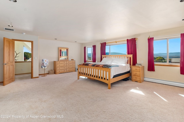 carpeted bedroom with a mountain view and baseboard heating