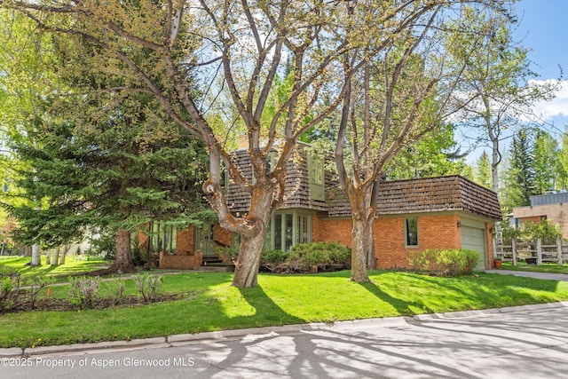 531 Gillespie St, Aspen, CO 81611 - view of front of house featuring mansard roof, brick siding, an attached garage, and driveway
