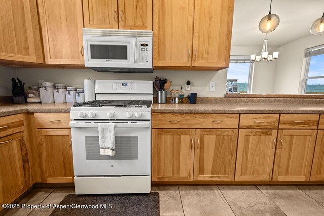 kitchen with white appliances, a chandelier, decorative light fixtures, and light tile patterned floors