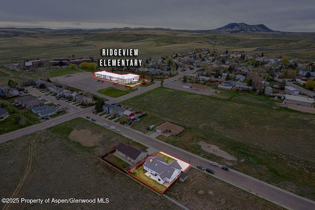 aerial perspective of suburban area with property parcel outlined and mountains