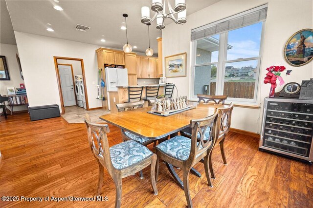 dining area featuring wine cooler, a chandelier, light wood-style floors, recessed lighting, and baseboards
