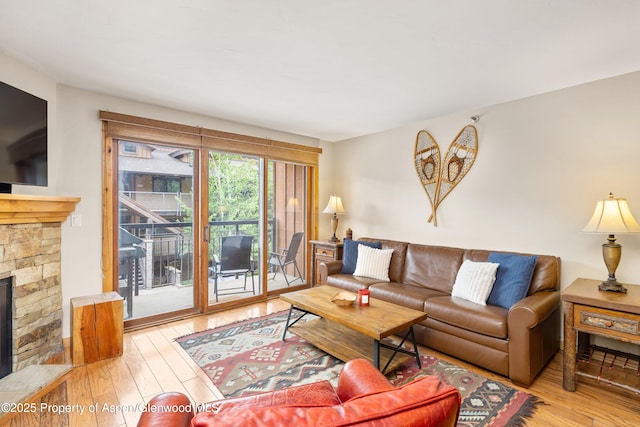 400 Wood Rd Unit 2104B, Snowmass Village, CO 81615 - living room featuring hardwood / wood-style flooring and a stone fireplace