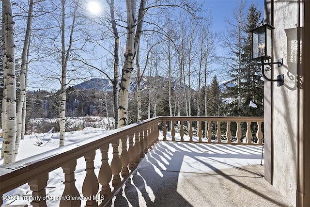 snow covered deck with a mountain view