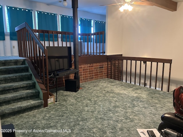 stairway featuring beam ceiling and a ceiling fan