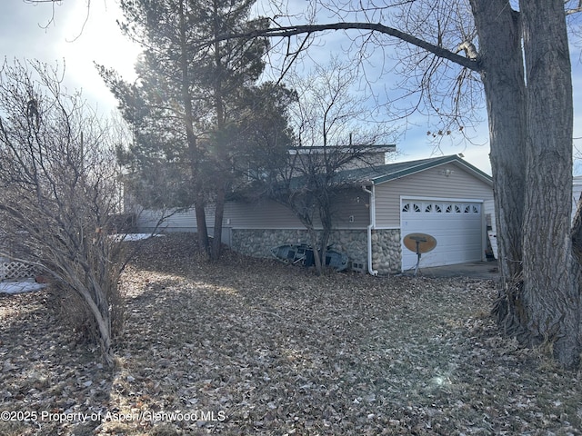 view of property exterior with stone siding and a garage