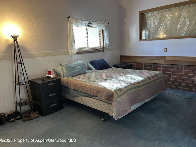 carpeted bedroom featuring a wainscoted wall