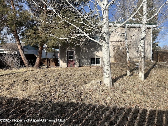 rear view of property featuring fence