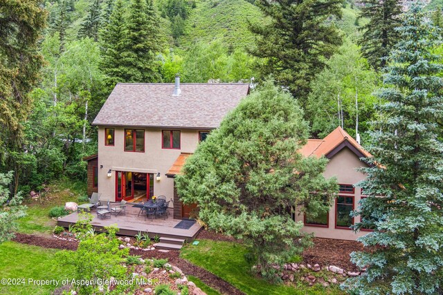135 Irwin Dr, Redstone, CO 81623 - back of property featuring stucco siding, a wooden deck, and a forest view