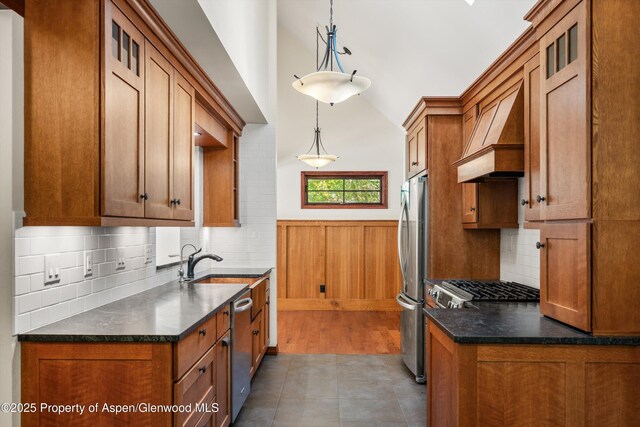 135 Irwin Dr, Redstone, CO 81623 - kitchen with appliances with stainless steel finishes, custom range hood, brown cabinets, lofted ceiling, and wainscoting