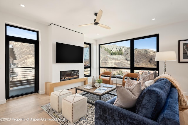 living room with ceiling fan and light hardwood / wood-style flooring