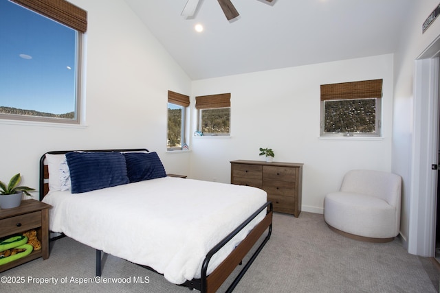 carpeted bedroom featuring ceiling fan, multiple windows, and lofted ceiling