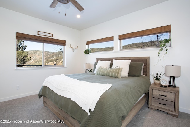 bedroom with carpet, ceiling fan, a mountain view, and multiple windows