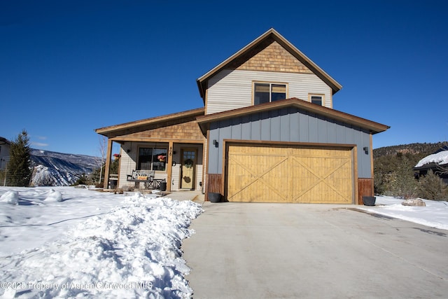 view of front facade with a garage, a porch, and a mountain view